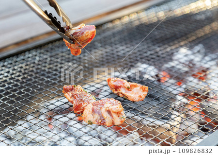バーベキューで焼かれる肉 109826832