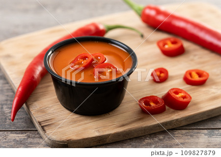 Spicy chili sauce in a bowl on wooden table Spicy chili sauce in a bowl on wooden table 109827879