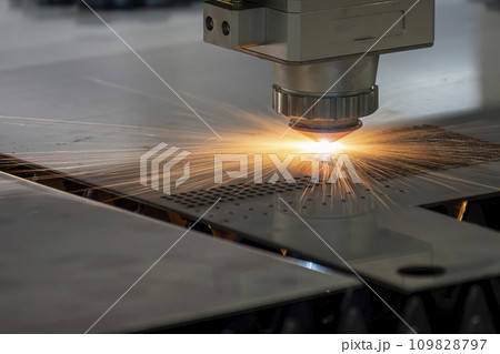The fiber laser cutting machine  cut the metal plate with the sparkling light. 109828797