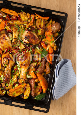Baked vegetables with baked chicken on a large metal griddle Baked vegetables with baked chicken on a large metal griddle 109830023