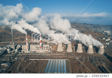 Aerial view of tall chimney pipes with grey smoke from coal power plant. Production of electricity with fossil fuel. Ecology and pollution of nature. 109830467