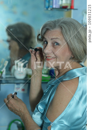 Portrait of beautiful old woman doing makeup Portrait of beautiful old woman doing makeup 109831215