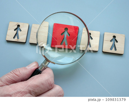 Figures and a hand with a magnifying glass. Employee evaluation. 109831379