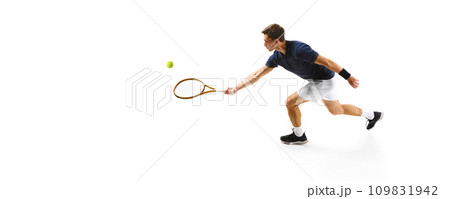 Top view. Concentrated man in his 30s, tennis athlete in motion during game,. practicing isolated over white background Top view. Concentrated man in his 30s, tennis athlete in motion during game,. practicing isolated over white background 109831942