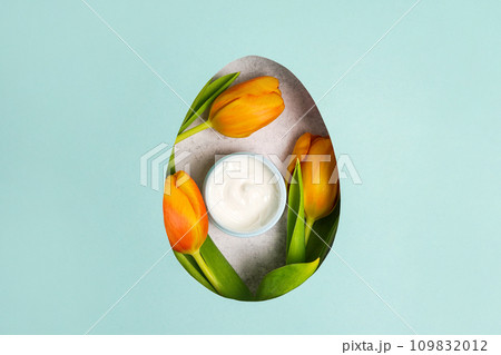 ?osmetics cream with yellow tulips in an easter egg. blue background with copy space ?osmetics cream with yellow tulips in an easter egg. blue background with copy space 109832012