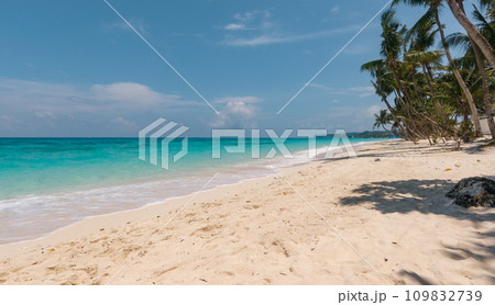Sandy tropical beach with palm trees and blue sea against the sky. Summer and travel vacation concept. Boracay, Philippines Sandy tropical beach with palm trees and blue sea against the sky. Summer and travel vacation concept. Boracay, Philippines 109832739
