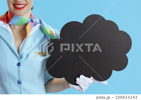 Female flight attendant on blue showing blank cloud shape board 109833243