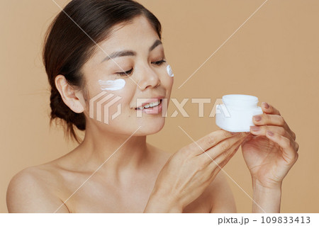 young asian woman with facial cream jar young asian woman with facial cream jar 109833413