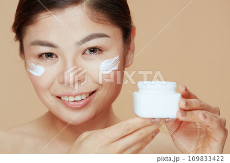 Portrait of modern asian woman with facial cream jar 109833422