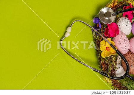 Medicine stethoscope with Easter eggs on spring green background. easter card with copy space Medicine stethoscope with Easter eggs on spring green background. easter card with copy space 109833637