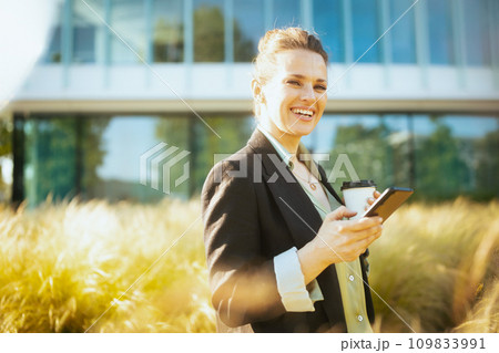 happy female worker in business district using smartphone 109833991