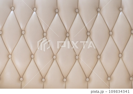 Elegant creamy beige leather upholstery texture with buttons for pattern or background 109834341