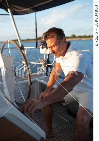 Man in white clothes sailing on a yacht Man in white clothes sailing on a yacht 109834903