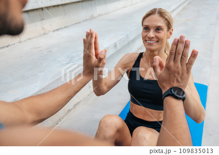 Fit woman doing sit-up with with personal trainer. 109835013
