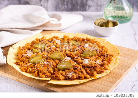 Smash burger tacos on tortilla with pickled cucumber and cheese on board 109835308