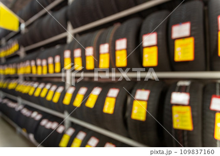 Blurred image rows of brand new tires for sale at retail store. 109837160