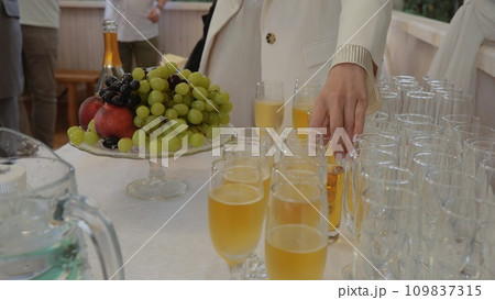 Table with drinks and fruits. Drinks are poured into glasses. Glassware. Reception of guests before the banquet, buffet. Table with drinks and fruits. Drinks are poured into glasses. Glassware. Reception of guests before the banquet, buffet. 109837315