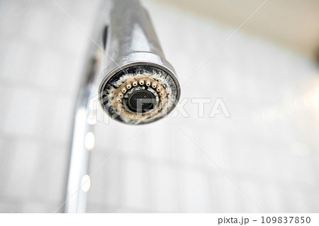 The chrome faucet is covered with lime scale. The chrome faucet is covered with lime scale. 109837850