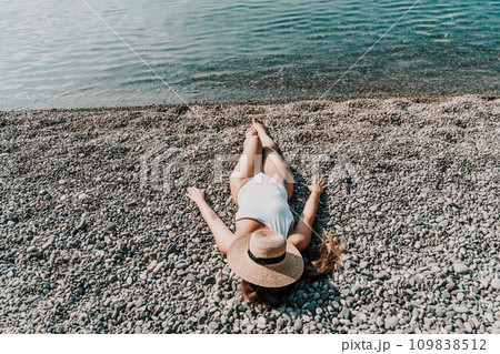 Woman white bikini beach tan. Happy woman in swimwear and hat on vacation. Summer travel holidays vacation on the sea Woman white bikini beach tan. Happy woman in swimwear and hat on vacation. Summer travel holidays vacation on the sea 109838512