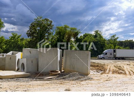 At construction site, concrete drainage sewage storm water manhole stacked are awaiting preparation to installation. 109840643