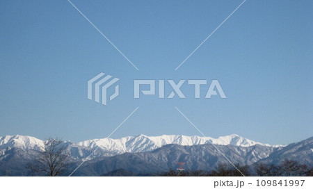 冬の晴れ間の雪山と青空 109841997