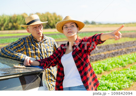 Farmers talking near car at farm field Farmers talking near car at farm field 109842094