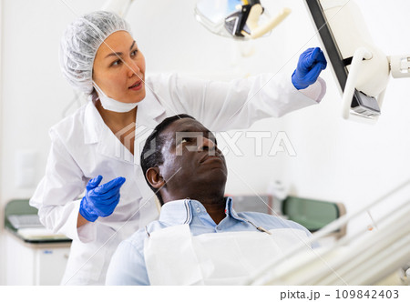 Doctor dentist shows the patient the result of dental x-ray 109842403