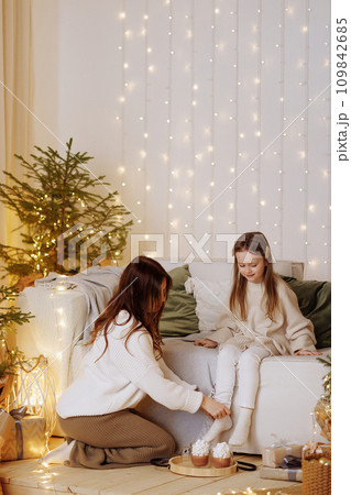 Mother and daughter enjoying cozy Christmas evening. 109842685