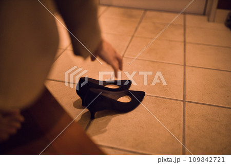 玄関でパンプスを脱ぐビジネスウーマン  ナイトルーティーン　 109842721