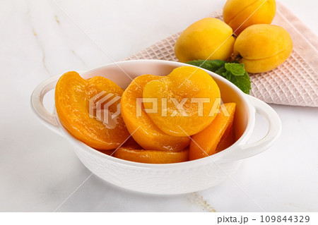 Few canned aprocots in the bowl 109844329