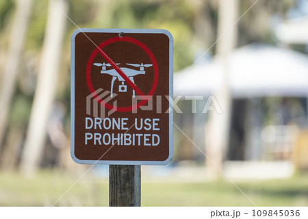 Signpost with warning about drone usage prohibition in state park. Warning notice against using UAV and quadcopters Signpost with warning about drone usage prohibition in state park. Warning notice against using UAV and quadcopters 109845036