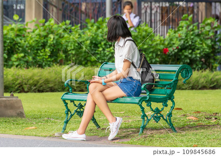 Woman sitting in the park 109845686