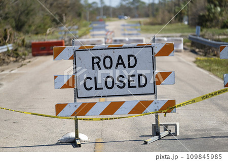 Yellow protective barrier at street construction site. Warning road sign about utility work Yellow protective barrier at street construction site. Warning road sign about utility work 109845985