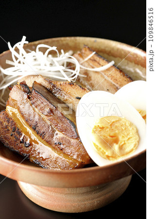 白髪葱乗せ厚切り炙りチャーシューとゆで卵を黒背景で撮影 白髪葱乗せ厚切り炙りチャーシューとゆで卵を黒背景で撮影 109846516