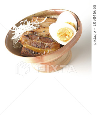 白髪葱乗せ厚切り炙りチャーシューとゆで卵を白背景で撮影 109846668
