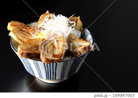 半熟卵乗せ厚切り炙りチャーシュー丼を黒背景で撮影 半熟卵乗せ厚切り炙りチャーシュー丼を黒背景で撮影 109847003