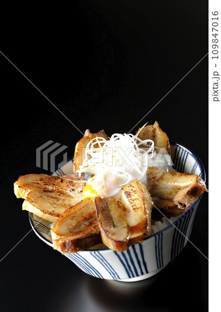 半熟卵乗せ厚切り炙りチャーシュー丼を黒背景で撮影 半熟卵乗せ厚切り炙りチャーシュー丼を黒背景で撮影 109847016