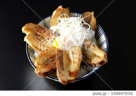半熟卵乗せ厚切り炙りチャーシュー丼を黒背景で俯瞰撮影 109847058