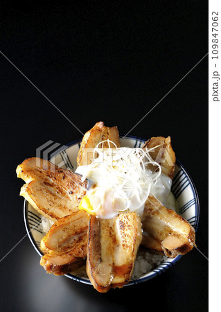 半熟卵乗せ厚切り炙りチャーシュー丼を黒背景で俯瞰撮影 109847062