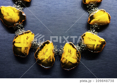 Fragment of an amber necklace, on a gray background. 109848738