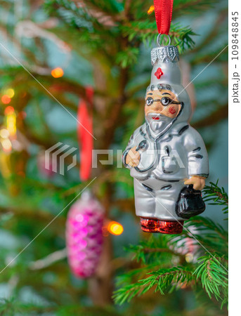 Glass New Year's toy Doctor hangs on a Christmas tree. Wishing you health in the new year 109848845