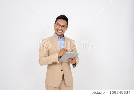 A professional Asian businessman is standing on an isolated white background with a digital tablet. 109849634