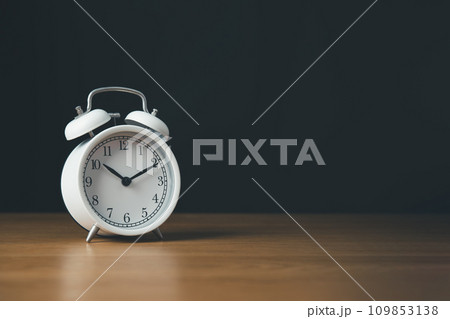 Time managment and Work management concept.Clock isolate on the wooden table and black background. Time managment and Work management concept.Clock isolate on the wooden table and black background. 109853138