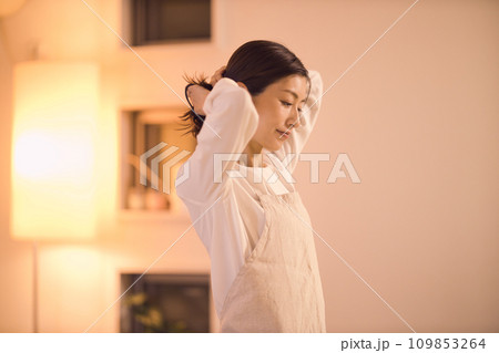 髪を結んでお夕食の準備をするビジネスウーマン  ナイトルーティーン 109853264