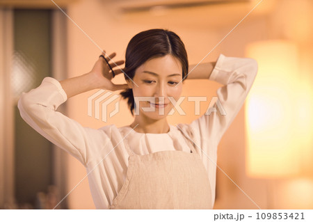 髪を結んでお夕食の準備をするビジネスウーマン  ナイトルーティーン 109853421