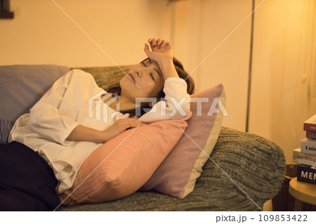 ジャケットを脱いでソファに倒れるビジネスウーマン 　ナイトルーティーン　 109853422