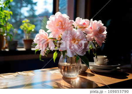 Luxurious bouquet of pink peonies in a vase on the table by the window. Cozy home decor Luxurious bouquet of pink peonies in a vase on the table by the window. Cozy home decor 109853790