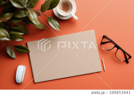 Office flat lay and top view. Black rimmed glasses, pen, coffee cup, blank sheet for copy space, green plant on orange background 109853841