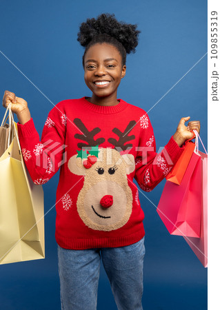 Happy african american woman with christmas gifts in hands Happy african american woman with christmas gifts in hands 109855319