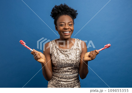 Smiling cute woman with christmas lollipops in hands Smiling cute woman with christmas lollipops in hands 109855355